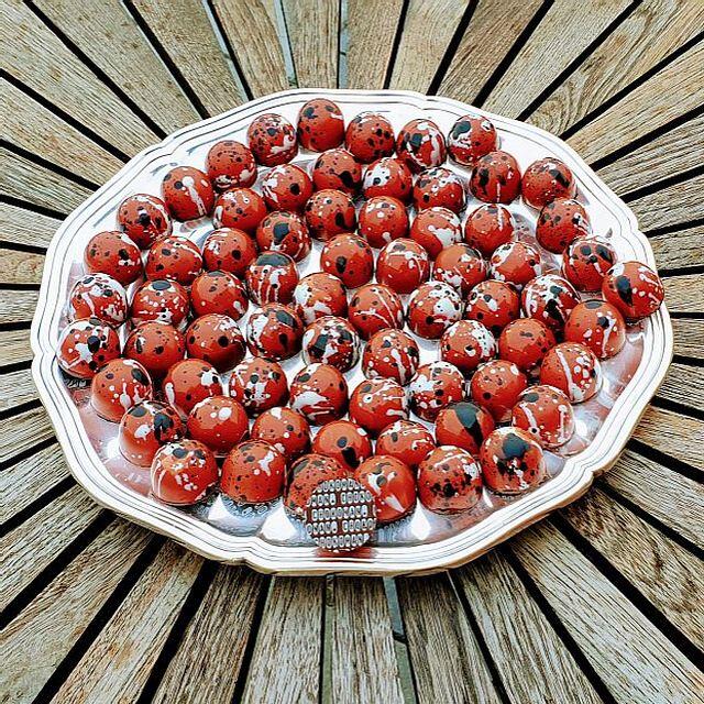 Fad med flotte røde chokolader lavet i form med spændende "splat" design af hvid og mørk chokolade og tryk i bunden.